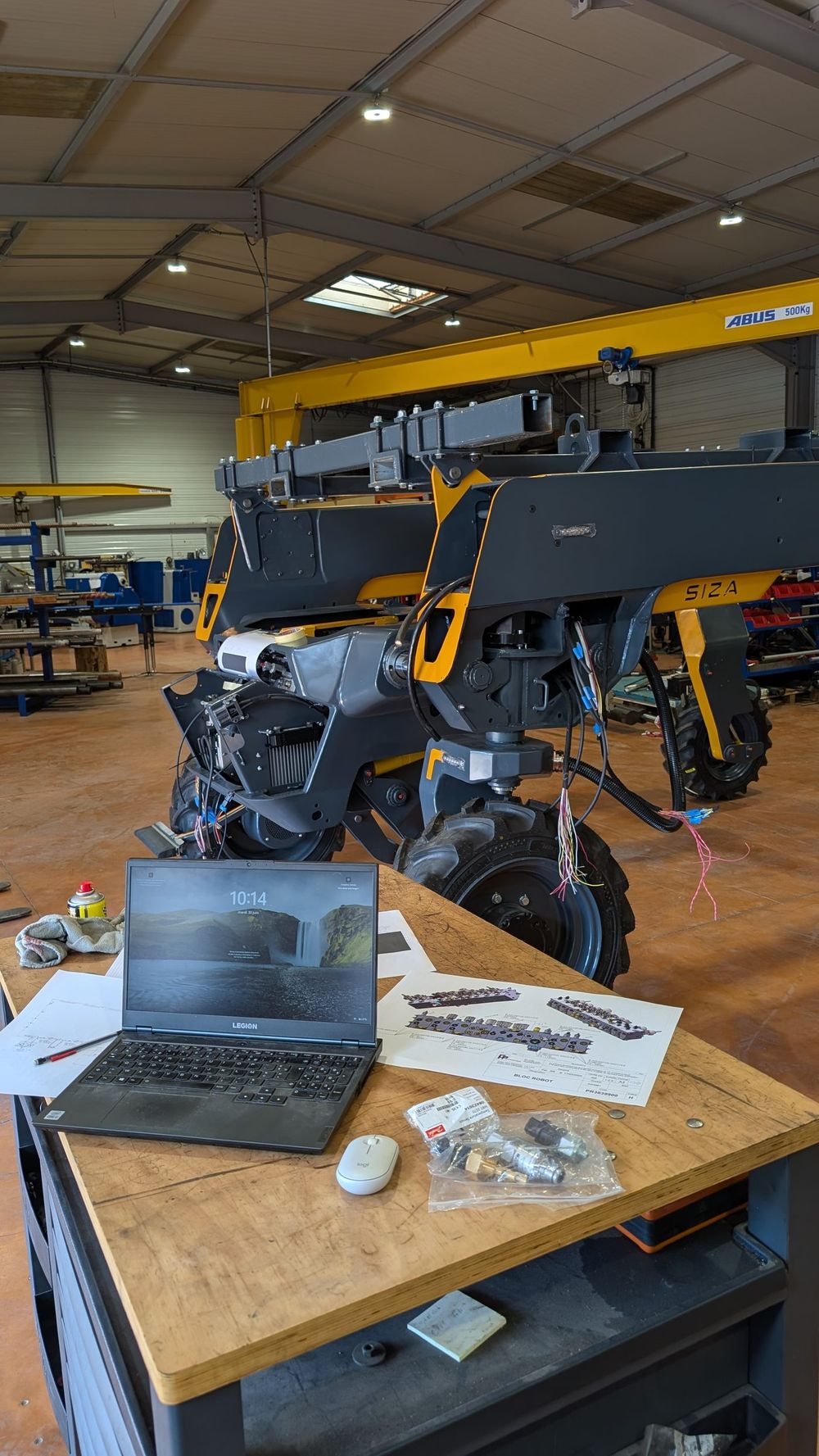 Ingénieur SIZA en mise au point du logiciel embarqué, au pied de la machine